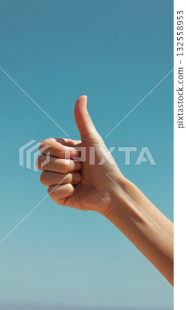 Thumbs up hand gesture against clear blue sky, positive approval, encouragement, cheerful mood Thumbs up hand gesture against clear blue sky, positive approval, encouragement, cheerful mood 132558953