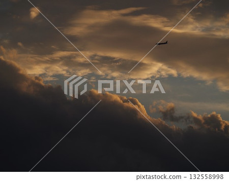 Airplane flying in a beautiful sunset sky 132558998