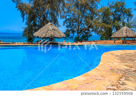 Swimming pool overlooking ocean. Tropical vacations concept 132559508