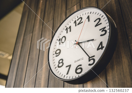 Time Clock hanging at modern wooden wall background, business times, office working hours concept. Time Clock hanging at modern wooden wall background, business times, office working hours concept. 132560237
