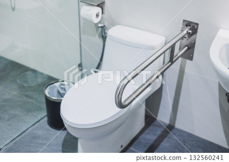 Handicap friendly restroom. Toilet Safety Rails, Clean toilet bowl with handle bar in bathroom 132560241