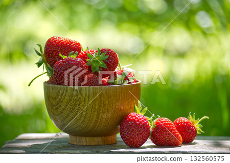 Fresh Strawberries in a Wooden Bowl on a Sunny Outdoor Day Fresh Strawberries in a Wooden Bowl on a Sunny Outdoor Day 132560575