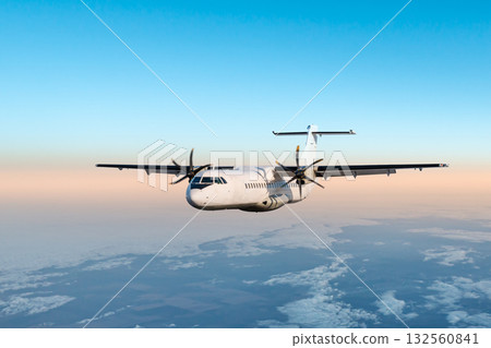 White passenger turboprop plane flying in the morning air above the clouds White passenger turboprop plane flying in the morning air above the clouds 132560841