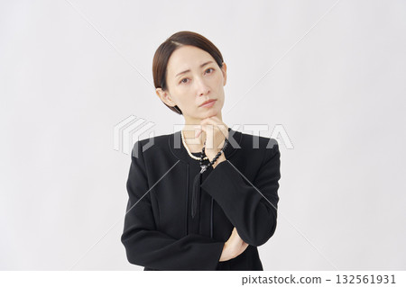 Thinking woman in mourning clothes looking at camera white background 132561931