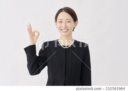 身著喪服的女子舉著OK手勢，白色背景 132561964