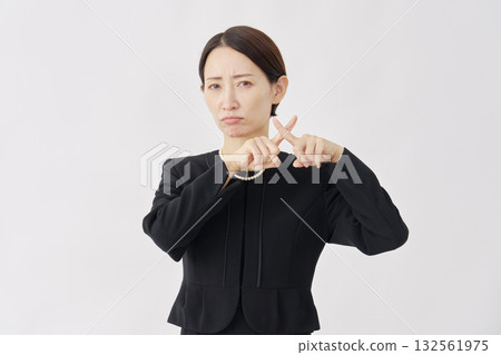 Woman in mourning clothes making a cross gesture on a white background 132561975