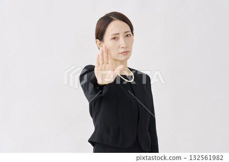 一位身著喪服的女子在白色背景上做出禁忌手勢。 132561982