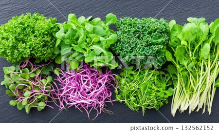 Artistic arrangement of kale and vibrant microgreens on a dark slate background showcasing modern food presentation ideas Artistic arrangement of kale and vibrant microgreens on a dark slate background showcasing modern food presentation ideas 132562152