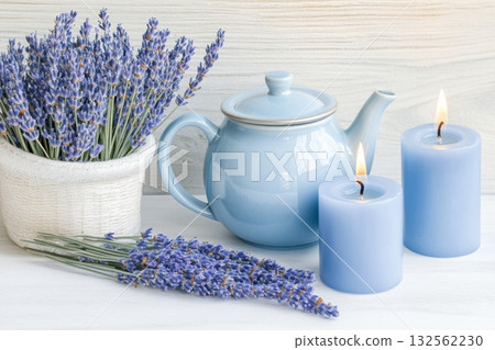 Calm still life composition featuring dried lavender, blue candles, and a vintage teapot that captures rustic charm and tranquility in a cozy setting 132562230