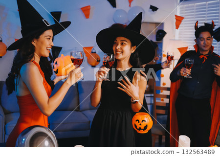 Joyful office Halloween party with coworkers in costumes, celebrating with drinks and laughter, fostering teamwork and festive spirit 132563489