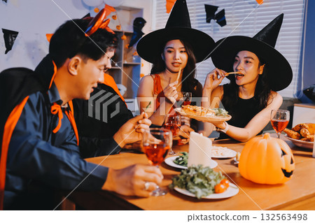 Joyful office Halloween party with coworkers in costumes, celebrating with drinks and laughter, fostering teamwork and festive spirit Joyful office Halloween party with coworkers in costumes, celebrating with drinks and laughter, fostering teamwork and festive spirit 132563498