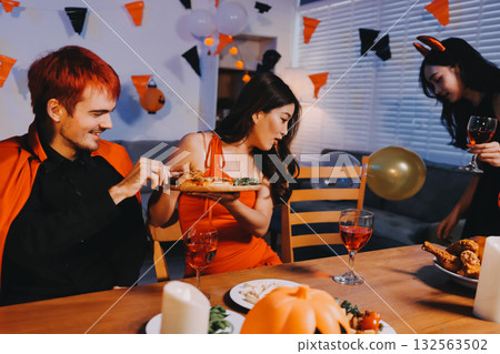 Joyful office Halloween party with coworkers in costumes, celebrating with drinks and laughter, fostering teamwork and festive spirit 132563502