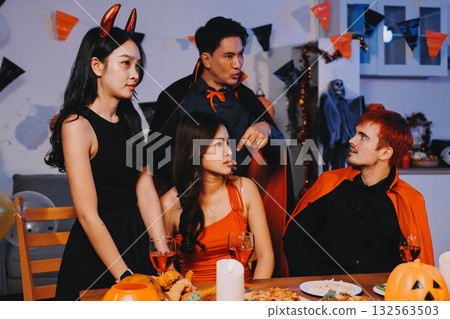 Joyful office Halloween party with coworkers in costumes, celebrating with drinks and laughter, fostering teamwork and festive spirit 132563503