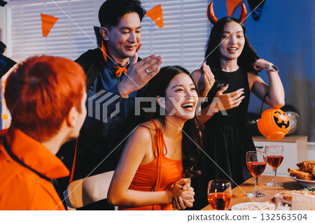 Joyful office Halloween party with coworkers in costumes, celebrating with drinks and laughter, fostering teamwork and festive spirit 132563504