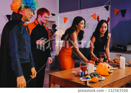 Joyful office Halloween party with coworkers in costumes, celebrating with drinks and laughter, fostering teamwork and festive spirit 132563508