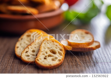 Crispy roasted bruschetta bread on wooden table. Crispy roasted bruschetta bread on wooden table. 132563922