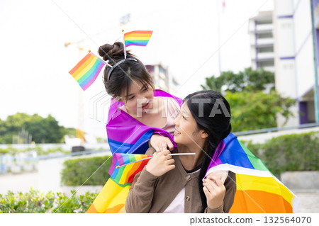 Women teen with colorful LGBTQ pride month rainbow flag, couple female happy smiling enjoy together 132564070