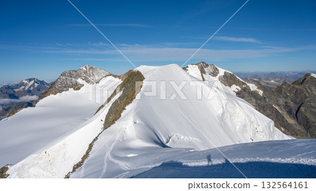 Piz Palu showcases its stunning snow-covered peaks under a clear blue sky. The breathtaking view captures the beauty of the Swiss Alps and surrounding glaciers, inviting exploration and adventure. 132564161