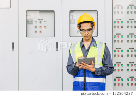 Professional Electrician Engineer man working check service electricity switch cabinet with tablet 132564287