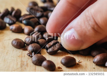 Close-up of Hand Picking Roasted Coffee. 132565031
