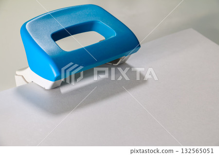 Paper Hole Puncher on White Sheet - Office Supply Close-Up 132565051