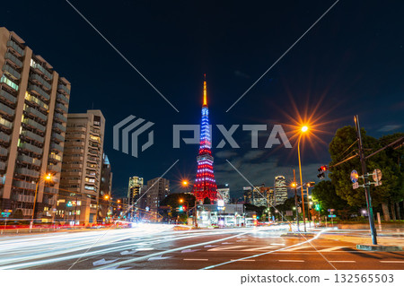 Tokyo Tower lit up in the colors of the American flag and the light trails of cars at an intersection 132565503