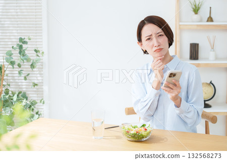 Woman eating salad and smartphone 132568273