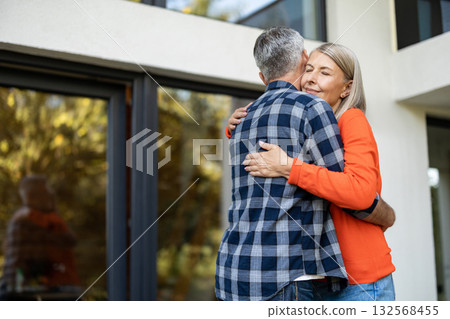 Long-haired woman in orange shirt hugging her husband 132568455