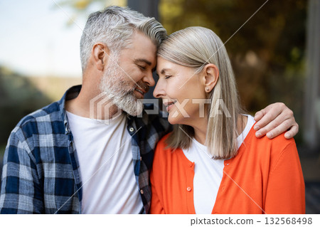 Gray-haired bearded man hugging woman tenderly and both feeling relaxed 132568498