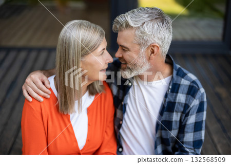 Man and woman sitting together hugging and feeling in love Man and woman sitting together hugging and feeling in love 132568509