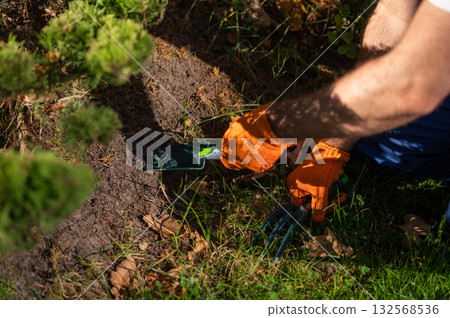 Gardener planting new flowers in soil during landscaping work outdoors Gardener planting new flowers in soil during landscaping work outdoors 132568536