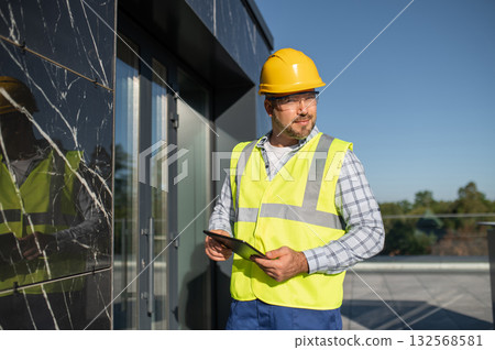 Technician using modern technology to inspect architectural surface Technician using modern technology to inspect architectural surface 132568581
