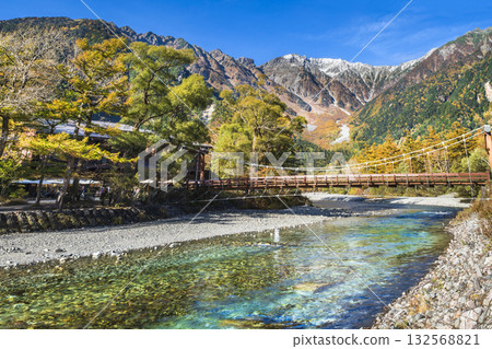 Spectacular autumn scenery in Kamikochi: Mount Hotaka with its beautiful autumn foliage and Kappa Bridge over the Azusa River [Matsumoto City, Nagano Prefecture] 132568821