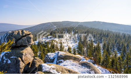 Pytlacke Rocks in the Jizera Mountains feature a stunning winter landscape. The sunny morning light illuminates the snowy scene, surrounded by evergreen trees and rocky formations. Pytlacke Rocks in the Jizera Mountains feature a stunning winter landscape. The sunny morning light illuminates the snowy scene, surrounded by evergreen trees and rocky formations. 132568996