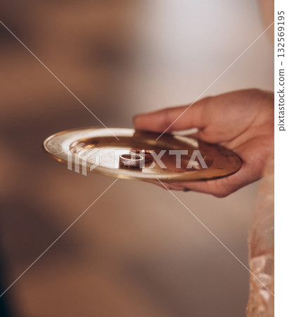 Priest holding golden tray with wedding rings in Orthodox church Priest holding golden tray with wedding rings in Orthodox church 132569195