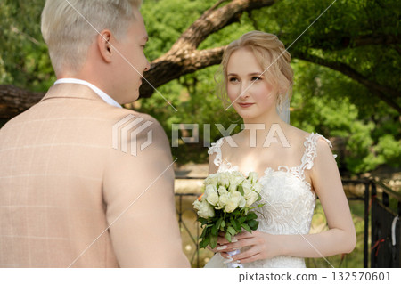 Couple exchanges vows in a serene outdoor setting during a wedding ceremony 132570601