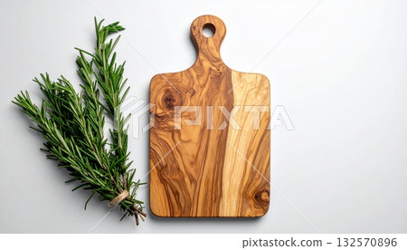 角落放著一塊木製砧板和迷迭香。 角落放著一塊木製砧板和迷迭香。 132570896