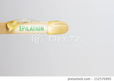 The inscription epilation on a wooden spatula with wax for hair removal. The inscription epilation on a wooden spatula with wax for hair removal. 132570995