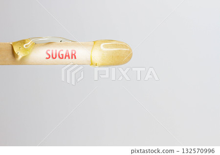The inscription sugar on a wooden spatula with wax for hair removal. The inscription sugar on a wooden spatula with wax for hair removal. 132570996