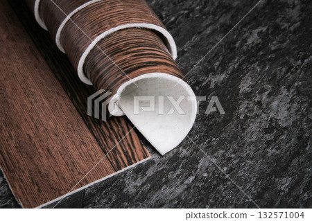 Linoleum. Roll of linoleum on a black background. Floor coverings. Linoleum. Roll of linoleum on a black background. Floor coverings. 132571004
