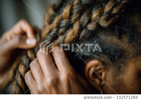 Close-up of hands braiding natural hair 132571269