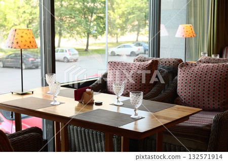 Enjoy a Cozy Restaurant Interior Featuring Comfortable Seating and Abundant Natural Light 132571914