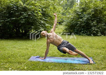Engaging in an Outdoor Yoga Pose amid the Tranquil Beauty of Nature and Greenery Engaging in an Outdoor Yoga Pose amid the Tranquil Beauty of Nature and Greenery 132571922