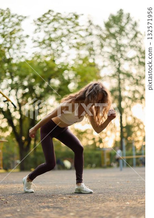 A dynamic outdoor fitness session featuring a young woman showcasing her athletic abilities A dynamic outdoor fitness session featuring a young woman showcasing her athletic abilities 132571956