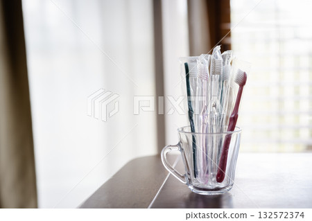 窗邊放著一個杯子和一把牙刷。 窗邊放著一個杯子和一把牙刷。 132572374