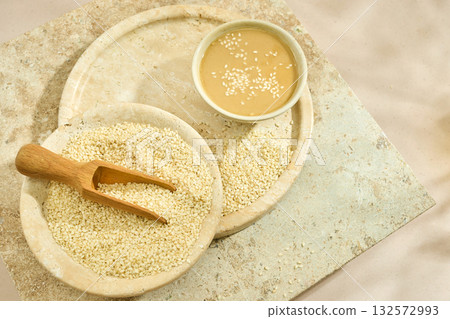 Sesame Tahini Bowl. A bowl of creamy tahini with sesame seeds on a rustic travertine surface. Sesame Tahini Bowl. A bowl of creamy tahini with sesame seeds on a rustic travertine surface. 132572993