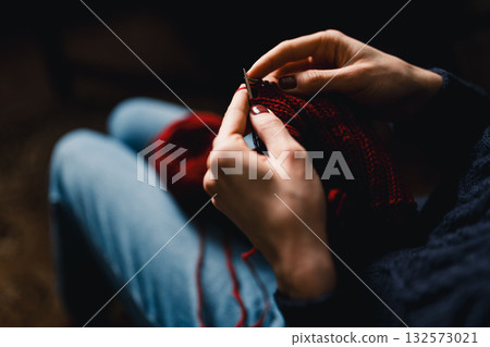 Cozy Knitting Session With Red Yarn: Hands Crafting A Warm Scarf For Relaxation And Home Comfort 132573021