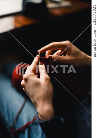 Cozy Knitting Session With Red Yarn: Hands Crafting A Warm Scarf For Relaxation And Home Comfort 132573023