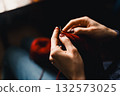 Cozy Knitting Session With Red Yarn: Hands Crafting A Warm Scarf For Relaxation And Home Comfort 132573025