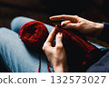 Cozy Knitting Session With Red Yarn: Hands Crafting A Warm Scarf For Relaxation And Home Comfort 132573027